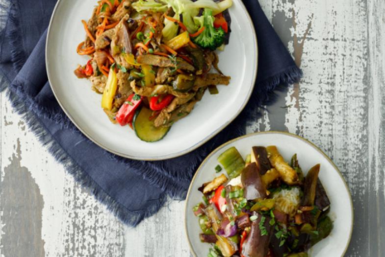 Two plates with stir fry vegetable dish shown from overhead.