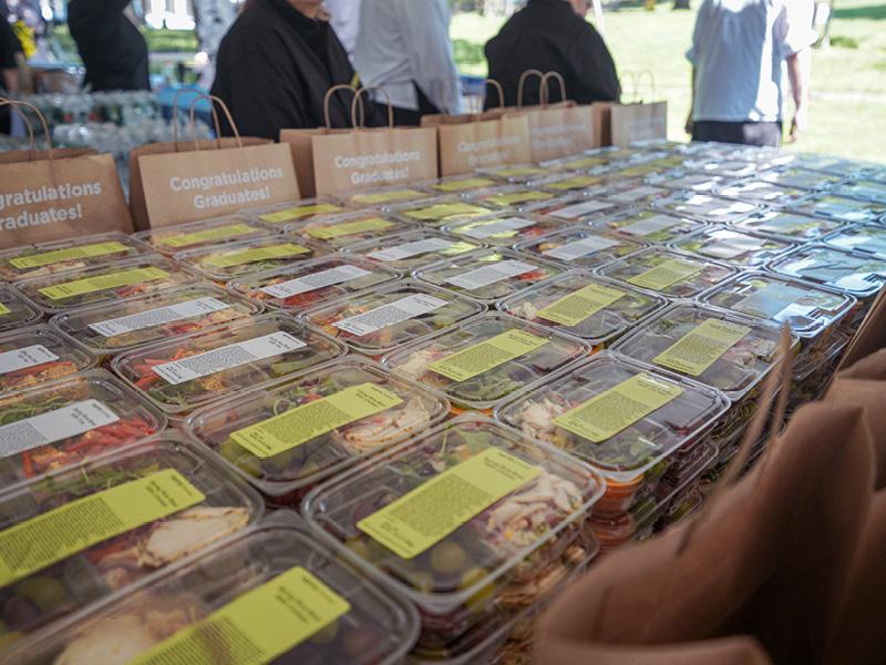 Rows of boxed lunches on a table at Tufts Commencement